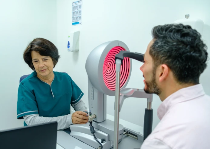 Especialista realizando examen de topografía corneal a un paciente con equipo Alcon Topolyzer