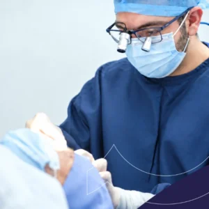 Especialista con lupas quirúrgicas atendiendo a un paciente en procedimiento de supraespecialidad oftalmológica.