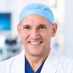 Dr. Victor Bohorquez, Director Científico de Clínica AVI, sonriendo en un entorno hospitalario