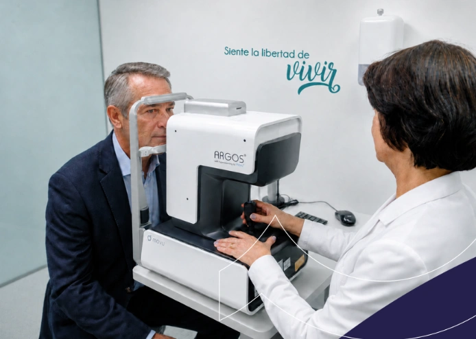 Hombre mayor realizando un examen de biometría ocular con una profesional en un consultorio moderno