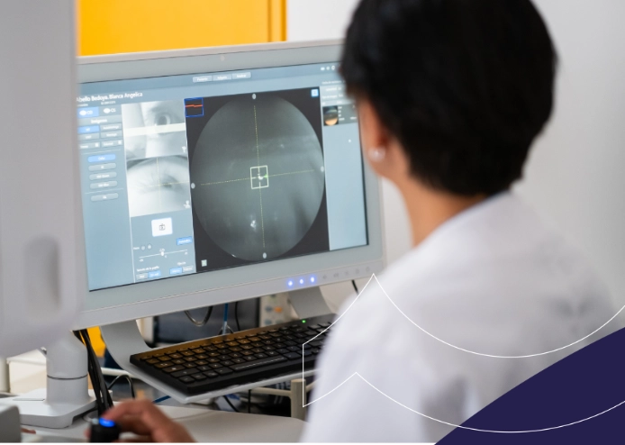 Oftalmólogo revisando imágenes detalladas del ojo en un monitor en Clínica AVI