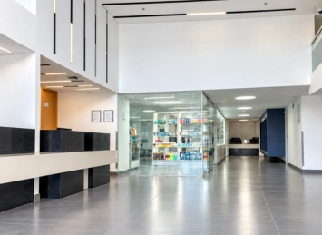 Vista de un pasillo en la Clínica AVI con recepción a la izquierda y farmacia al fondo