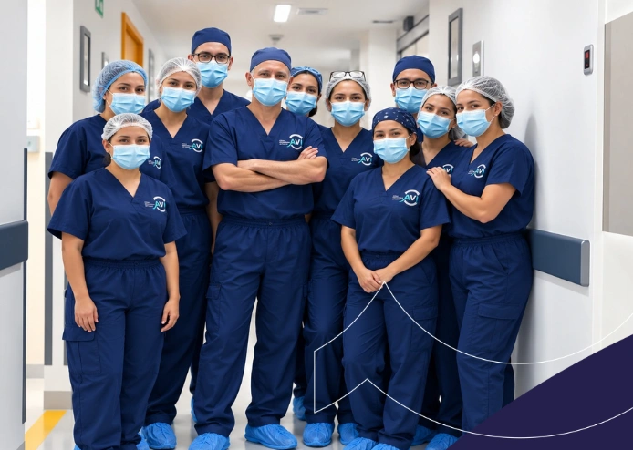 Equipo de médicos oftalmólogos y personal de Clínica AVI posando en un pasillo hospitalario