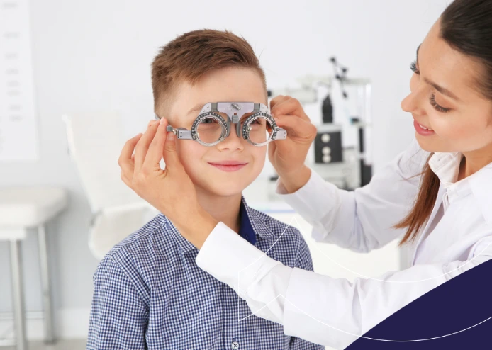 Oftalmóloga ajustando gafas de prueba a un niño en una clínica